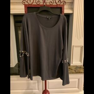 Grey knit top with embellished sleeves.